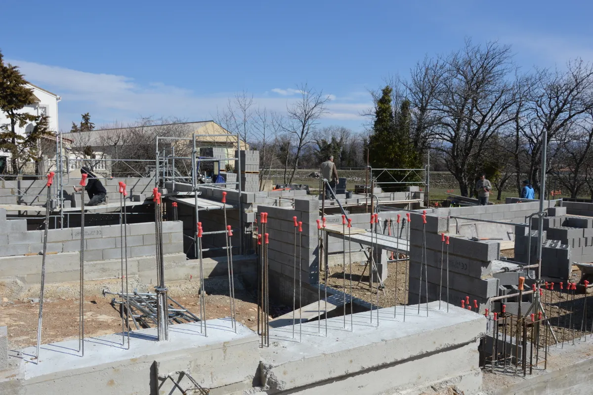 Obra de vivienda con muros de bloque y varillas de refuerzo a la vista