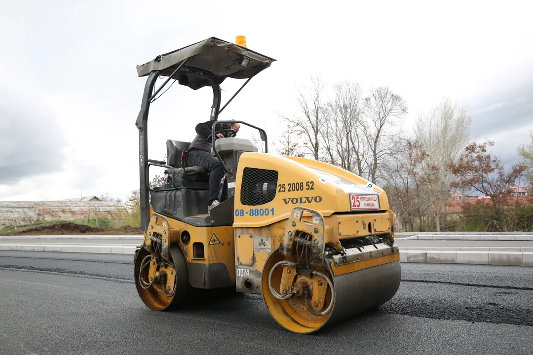 Rodillo compactador consolidando una capa de asfalto recién extendida en obra vial