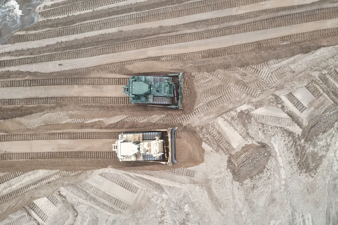 Dos buldóceres conformando y nivelando la explanación de un lote, vista aérea