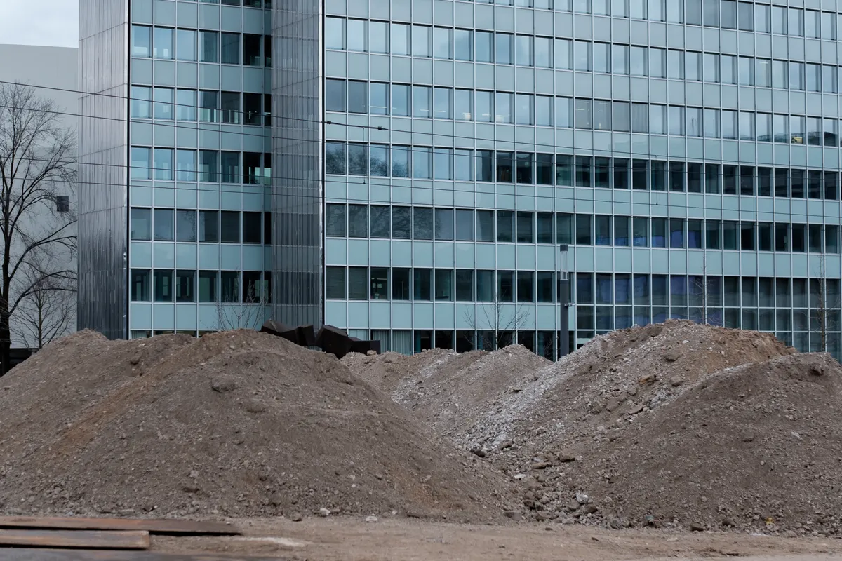 Montones de material granular de relleno descargados en un lote urbano en obra